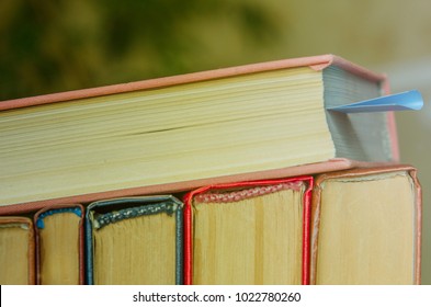 A Stack Of Colorful Books. One Lies With A Bookmark. Education, Knowledge, Learn, Study And Wisdom Concept. Horizontal Layout Of Childrens Books. Front Of Books With Colorful Covers.