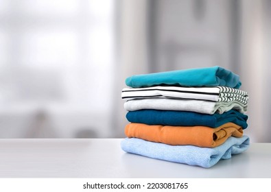 Stack of colorful clothes. Pile of clothing on table empty space background. Laundry and household. - Shutterstock ID 2203081765