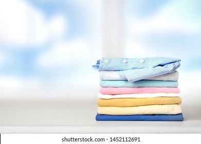 Stack of colorful cotton clothes on empty space background.