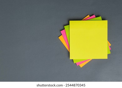 stack of colorful empty sticky notes with copy space on gray background