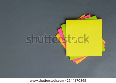 stack of colorful empty sticky notes with copy space on gray background