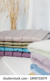 Stack Of Colorful Quilted Baby Blankets. Natural