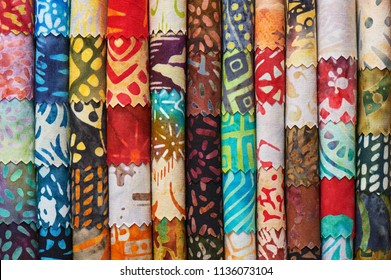 Stack of colorful quilting batik fabrics as a vibrant background image