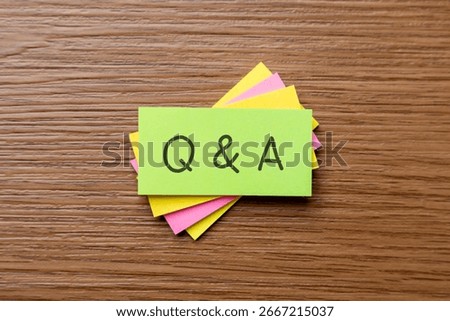 A stack of colorful sticky notes with handwritten letters "Q and A". Communication, problem-solving, and information exchange concept.