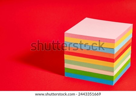 Stack of colorful sticky notes isolated on red background. Note block with memos