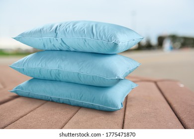 Stack of comfortable cozy pillows on wooden desk