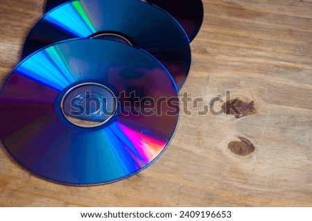 Stack of compact discs isolated on a wooden  background. Top view.