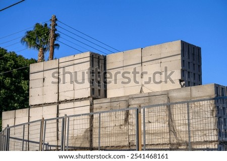 Stack of concrete blocks at a construction site against a bright blue sky