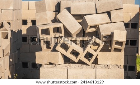 Stack of concrete blocks in disarray, seemingly about to fall apart, on a residential construction site on a sunny morning in Florida, for concepts of contrast, order and disorder, yin and yang