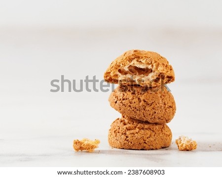 Stack of cookie amaretti on white marble background - traditional Italian Sardinian pastry. Delicious amaretti biscuit cookies made from almond or apricot kernels with copy space