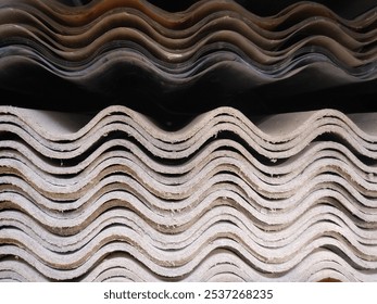 Stack of corrugated asbestos roofing sheets.