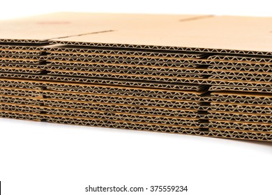 stack of corrugated cardboard boxes on white background. side perspective view of flattened boxes.