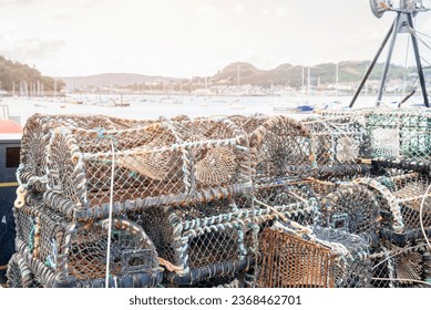 Stack of crab pots on a quay in a fishing harbour at sunset