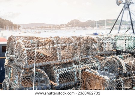 Stack of crab pots on a quay in a fishing harbour at sunset