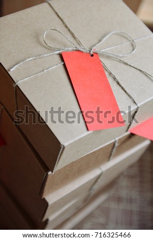 stack of craft boxes with gifts tied with a cord with tag