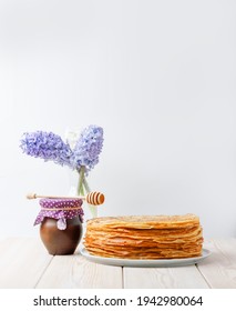 Stack Of Crepes With Honey Clay Jug And Spring Flowers On Wooden Table. Side View, Copy Space.