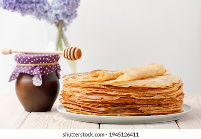 Stack Of Crepes With Honey Clay Jug And Spring Flowers On Wooden Table. Side View, Copy Space.