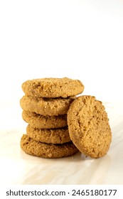 A stack of crunchy ginger biscuits of cookies placed on a marble worktop with white background. Selective focus. Copy space.