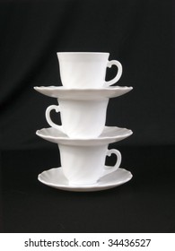 A stack of cups and saucers on the black background