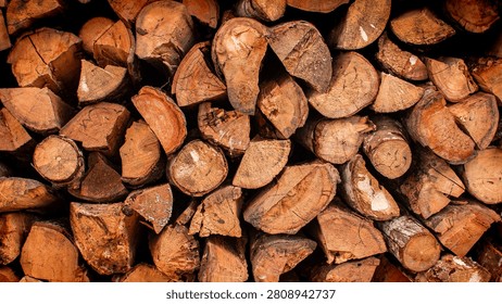 Stack of Cut Firewood Logs Background – Natural Timber Texture. Close-up of a neatly stacked pile of cut firewood logs, showcasing natural wood grain, tree rings, bark textures, and warm earthy tones. Ideal as a rustic background or texture for forestry, lumber, sustainable energy, woodworking, camping, and nature-related projects.