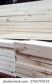 Stack of cut wooden planks in workshop. Raw lumber board pile for furniture manufacturing or renovation. Construction material for carpentry industry and sustainable building development.