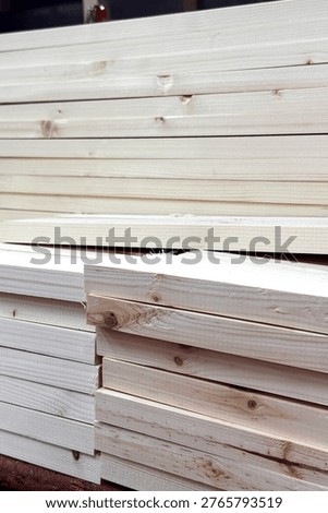 Stack of cut wooden planks in workshop. Raw lumber board pile for furniture manufacturing or renovation. Construction material for carpentry industry and sustainable building development.