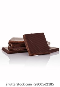 Stack of delicious dark chocolate squares on white