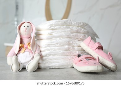 Stack Of Diapers And Baby Accessories On Counter In Bathroom, Closeup