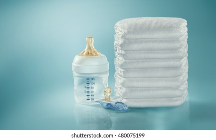 Stack Of Diapers. Baby Bottle And Pacifier. Studio Shot. Isolated