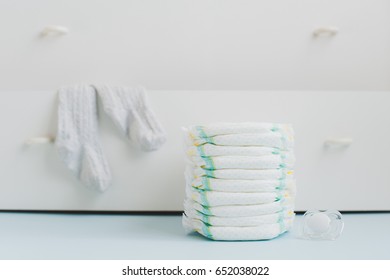 A Stack Of Diapers And A Locker With Linens