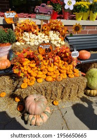 Stack of differebt colored pumpkins on a hay bale 
