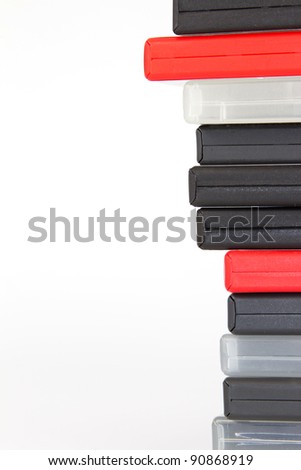 Stack of different colored DVD cases in front of a white background