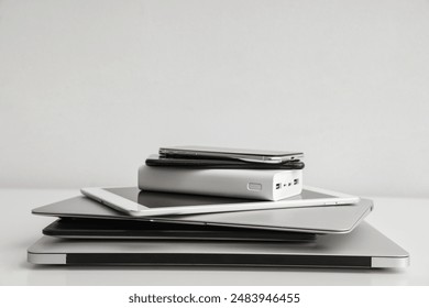 Stack of different modern gadgets on light background