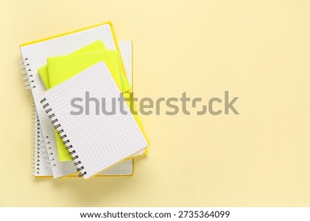 Stack of different notebooks on beige background