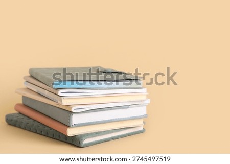 Stack of different notebooks on beige background