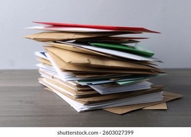 Stack of different paper envelopes on wooden table, closeup. Post office