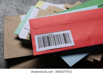 Stack of different paper envelopes on dark grey table, closeup. Post office