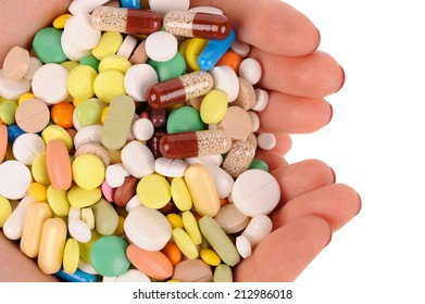 Stack of different pills in the hands over white background 