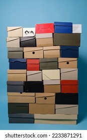 Stack of different shoe boxes on blue background. Place for text. 