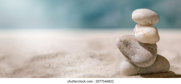 Stack of different smooth stones in balancing composition on summer sand sea beach with waves at background. Copy space creative layout. Banner vacation balance concept. - Shutterstock ID 2077546822