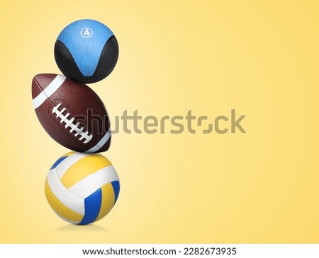 Stack of different sport and medicine balls on light gold background, space for text