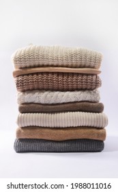 Stack of different warm sweaters isolated,