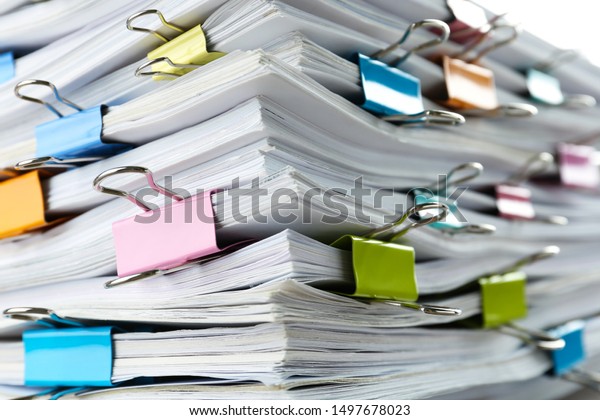 Stack of documents with binder clips as background,\
closeup view