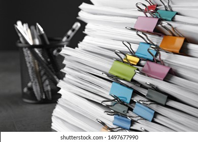Stack of documents with binder clips on grey stone table, closeup view