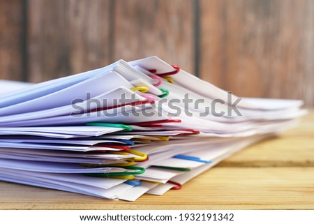 stack of documents with binder clips wooden table