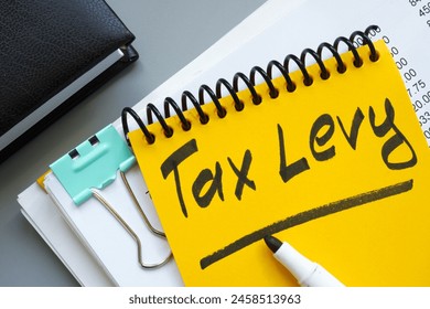 Stack of documents and notepad with inscription tax levy.