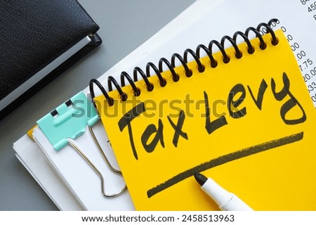 Stack of documents and notepad with inscription tax levy.