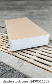 A stack of drywall sheets. Warehouse or shop of building and decoration materials. Wholesale or retail sale. Logistics and warehousing.
