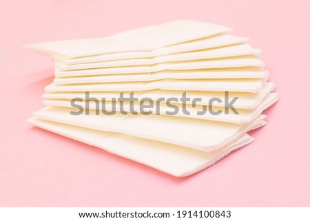 Stack of Eco clean paper napkins on pink background.