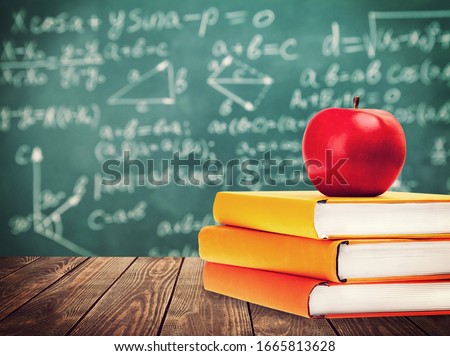 Stack of educational books and apple on the desk